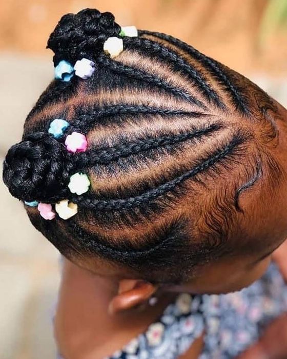 Child's cornrows finished in two buns with pastel beads