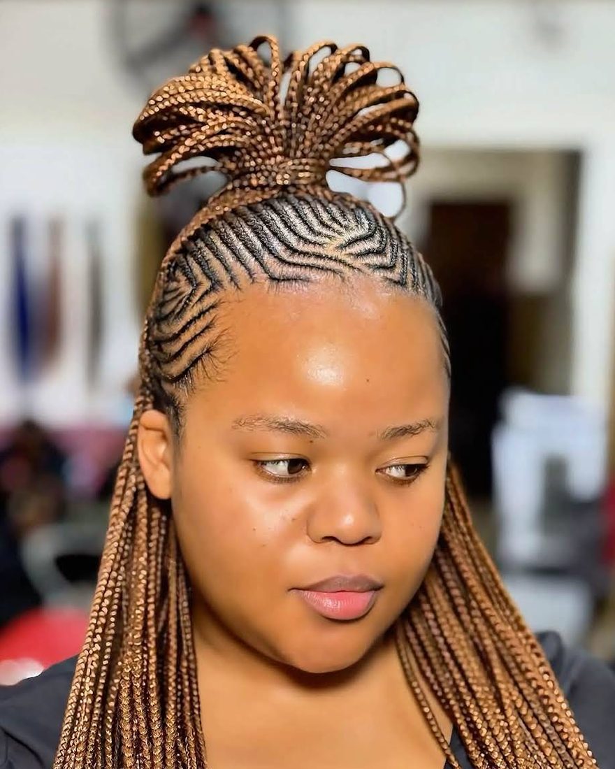 Client with honey-brown Fulani braids, zig-zag cornrows at the front and a looped top knot